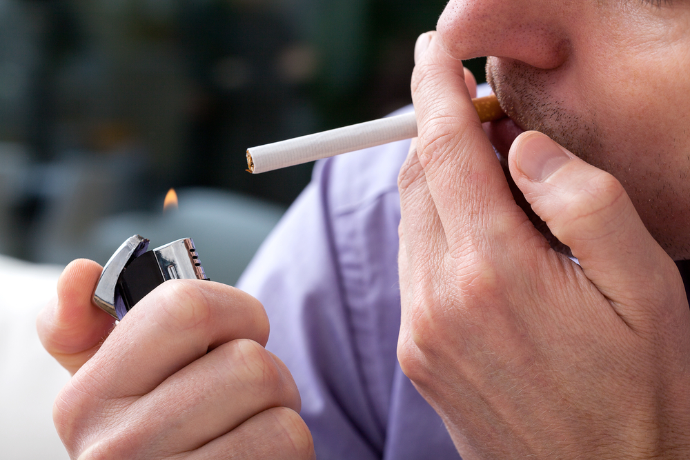 Young,Man,Lighting,Up,A,Cigarette,With,A,Lighter,closeup