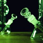 Glass,Bongs,On,Wooden,Table,Against,Black,Background,,Toned,In