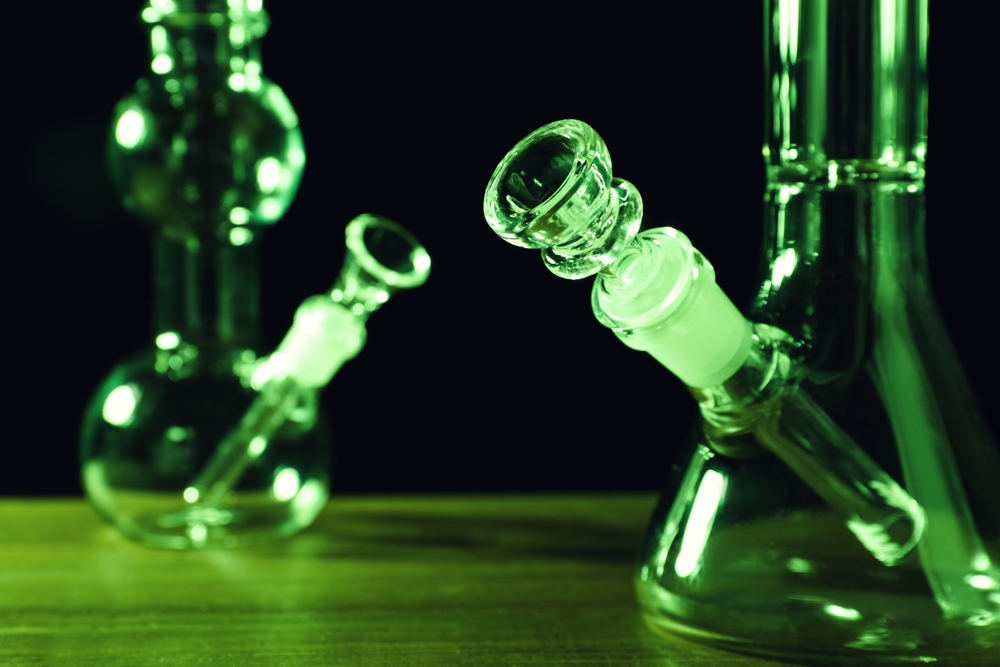 Glass,Bongs,On,Wooden,Table,Against,Black,Background,,Toned,In